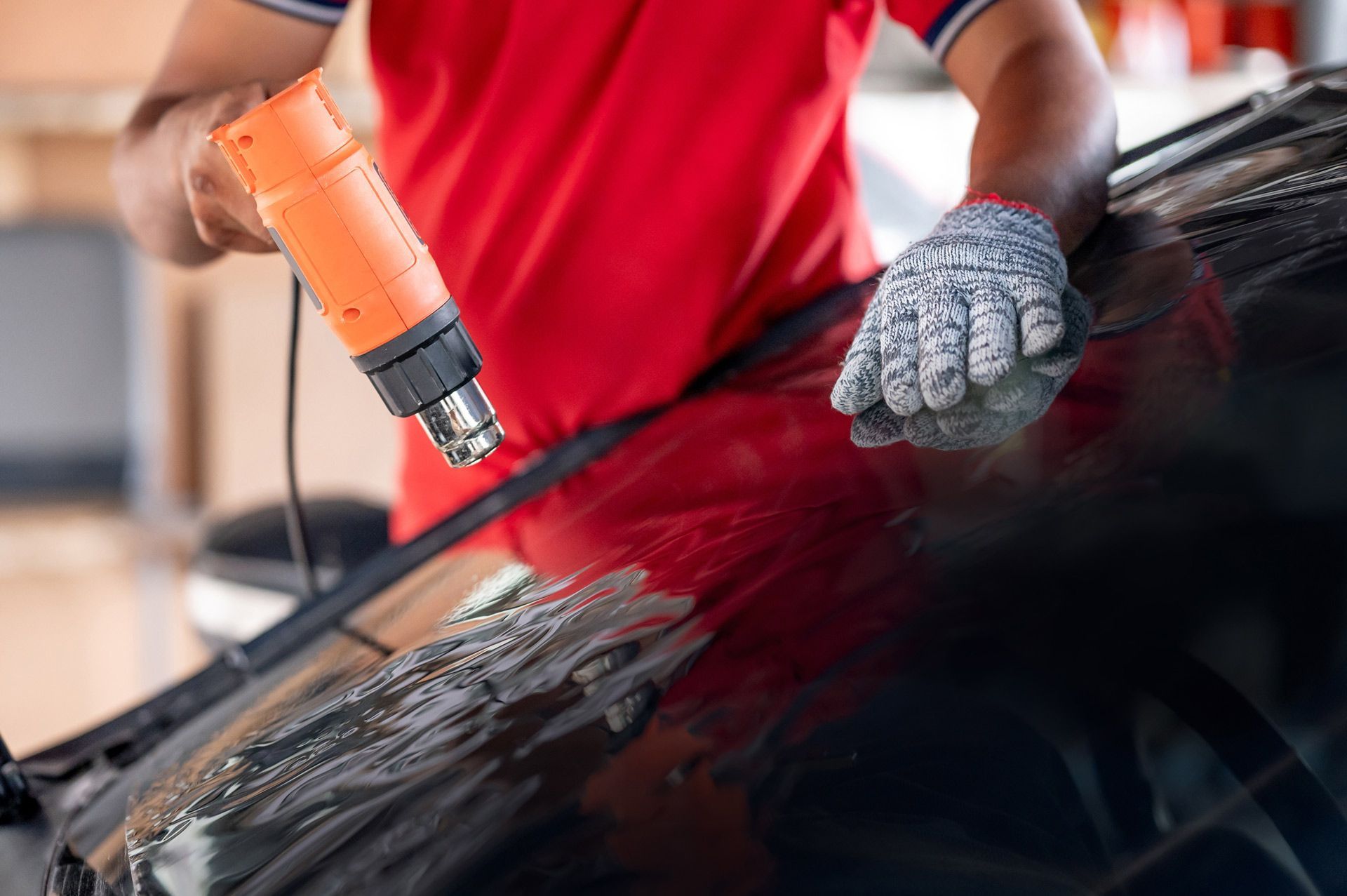 A man is applying window tinting to a car.