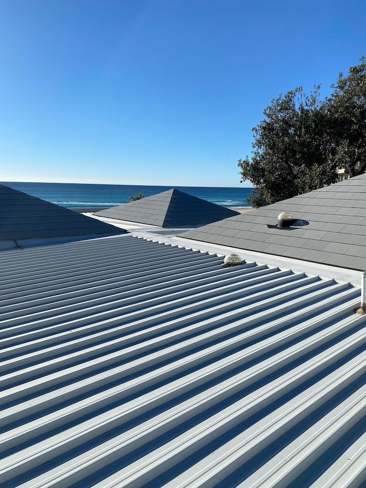 The roof of a house with a view of the ocean.