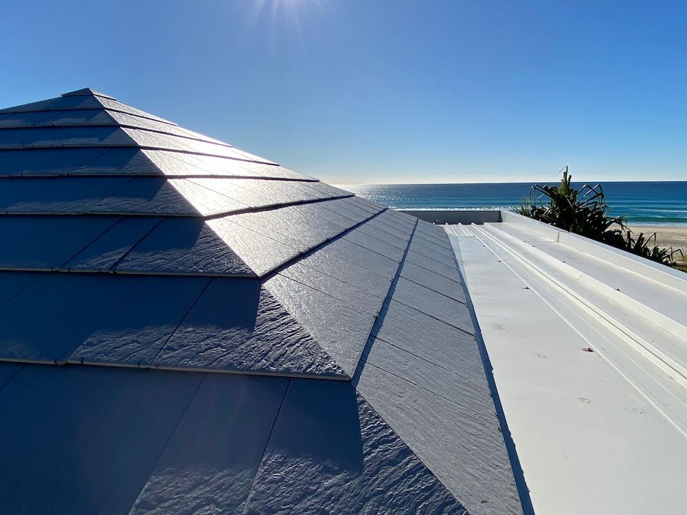 A roof with a view of the ocean on a sunny day.