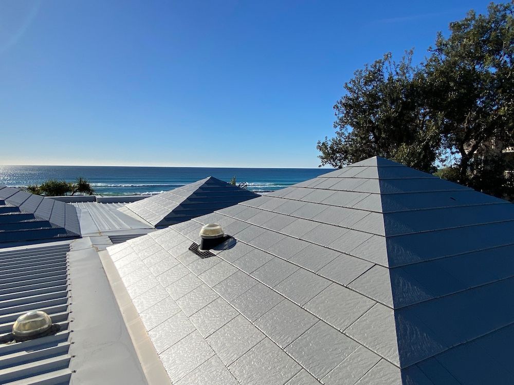 The roof of a house with a view of the ocean.