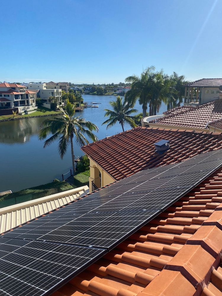 A roof with solar panels on it and a view of a lake.