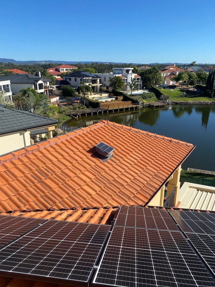 A Roof With a Lot of Solar Panels on It and a Lake in the Background — Killiby & Co Roofing Pty Ltd In Mudgeeraba, QLD