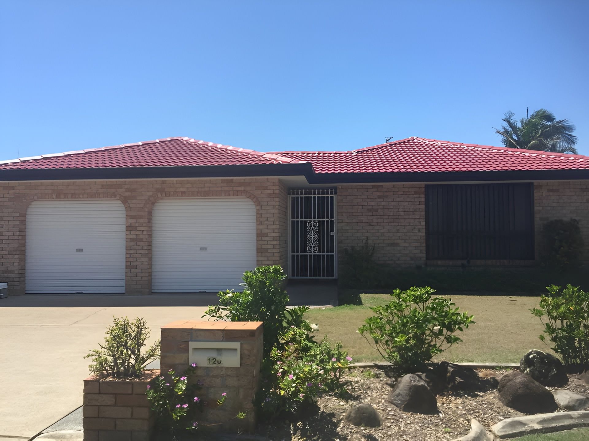 Brick Home With Red Tile Roof, Two-car Garage, and Small Garden — Killiby & Co Roofing Pty Ltd in Currumbin, QLD