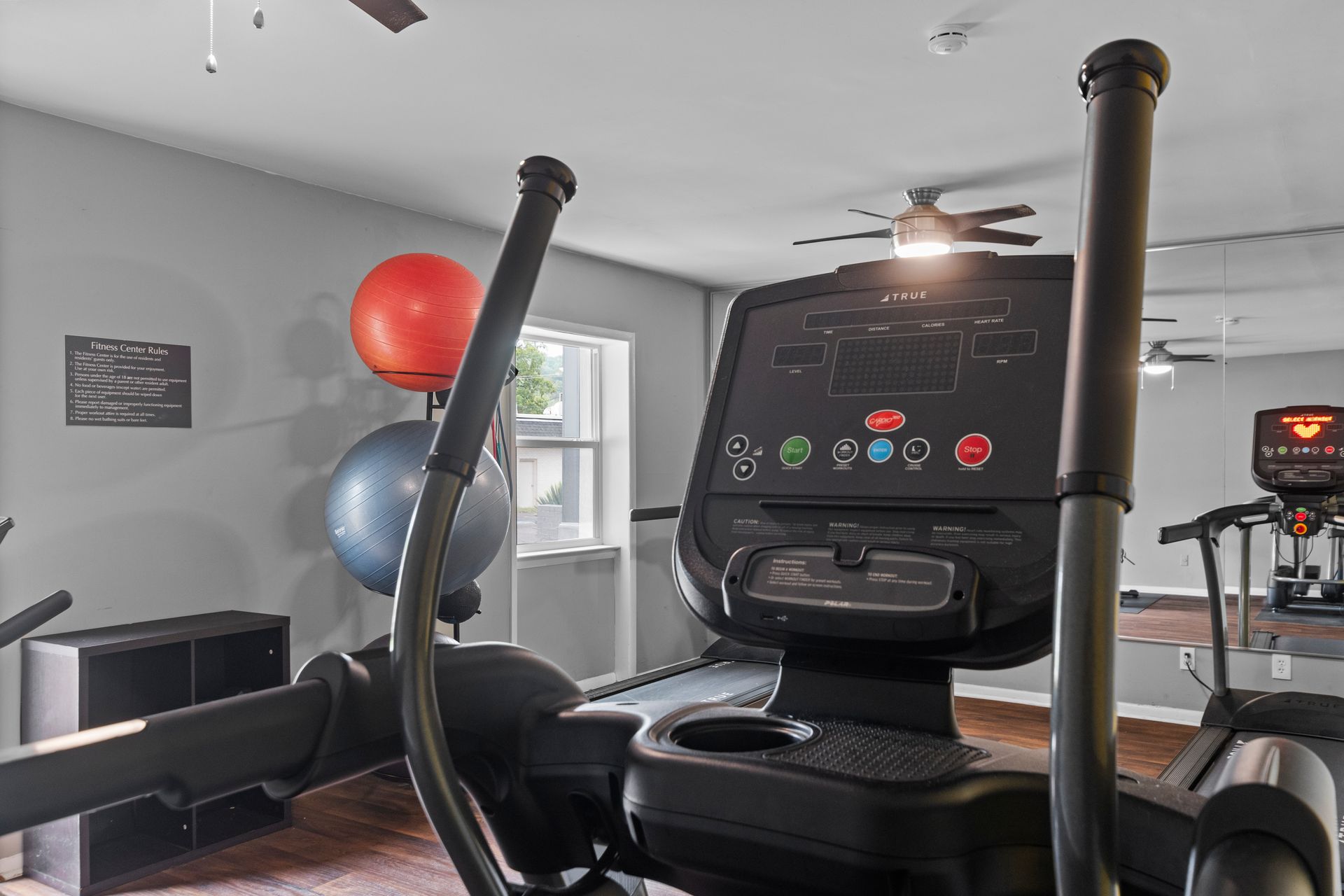 A close-up view of an elliptical machine’s console in a fitness room, with exercise balls visible in the background.