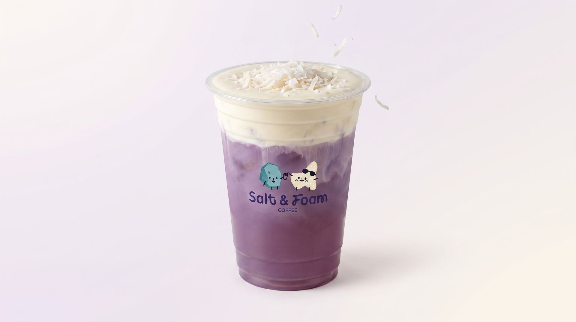 Purple iced drink in a clear plastic cup with a cream-colored foam top, on a white background
