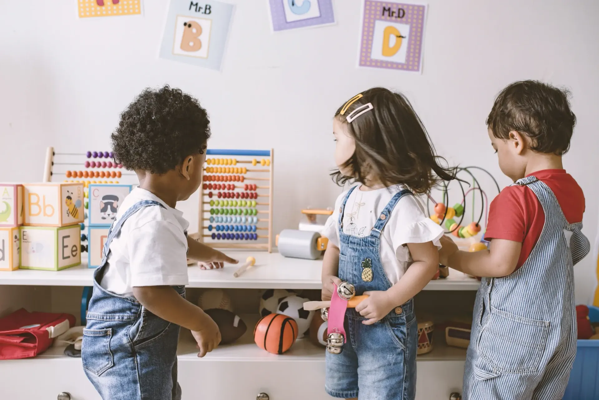 A group of children are playing with toys in a classroom.