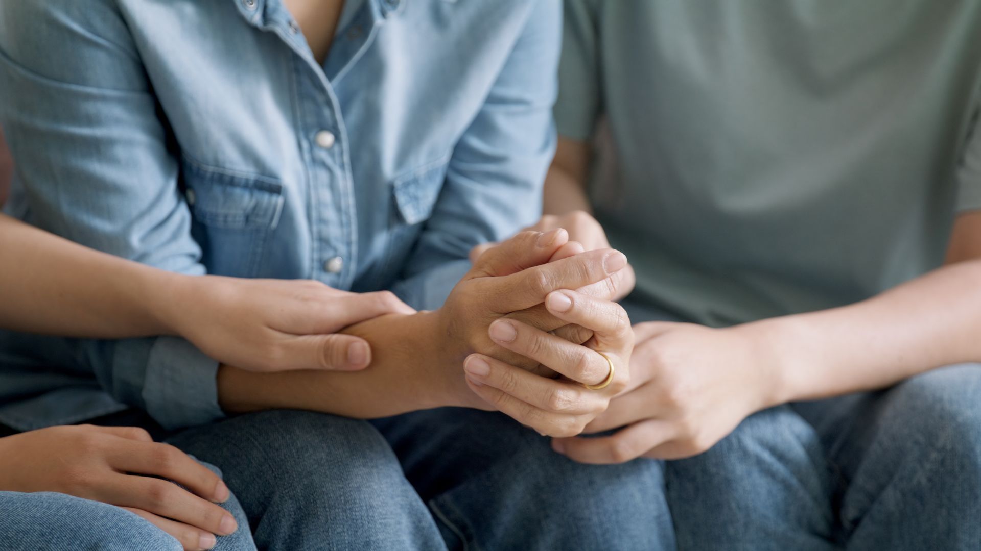 Hands clasped together, possibly offering comfort and support.