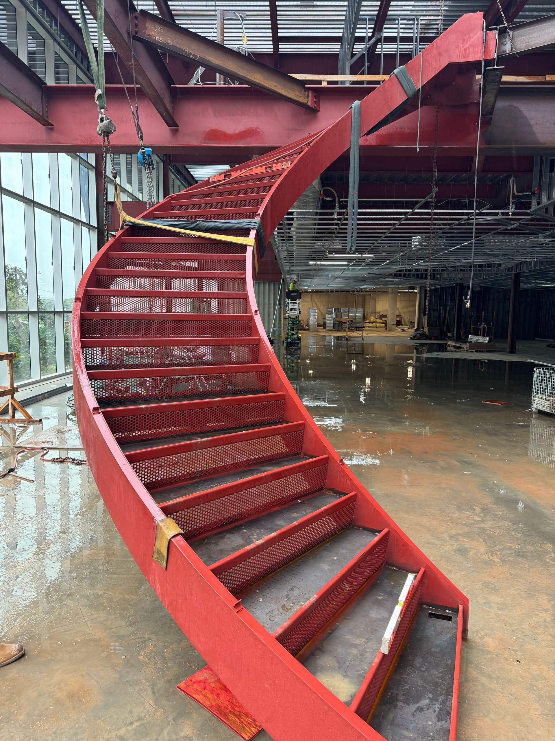 red curved custom steel stairs in a building that is build constructed
