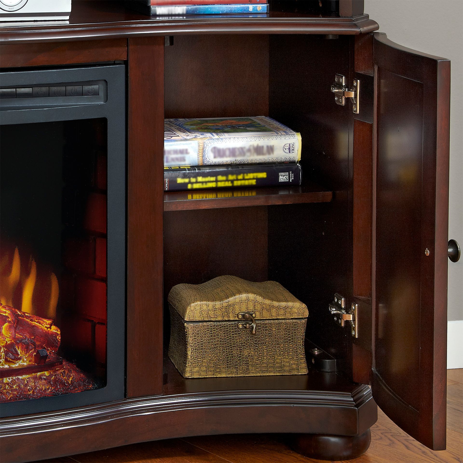 Fireplace entertainment center with open cabinet; dark wood, flickering flames, movies, and a decorative box.