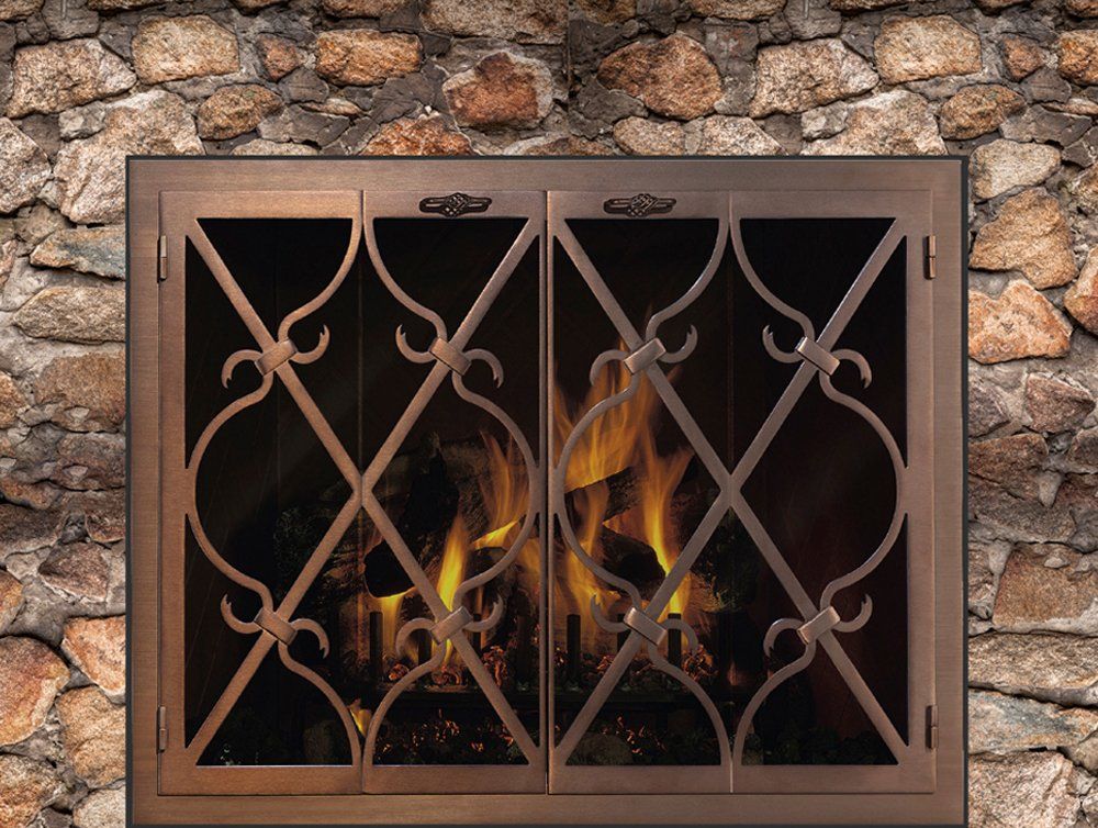 Fireplace with bronze-toned metal screen and flames against a stone wall background.