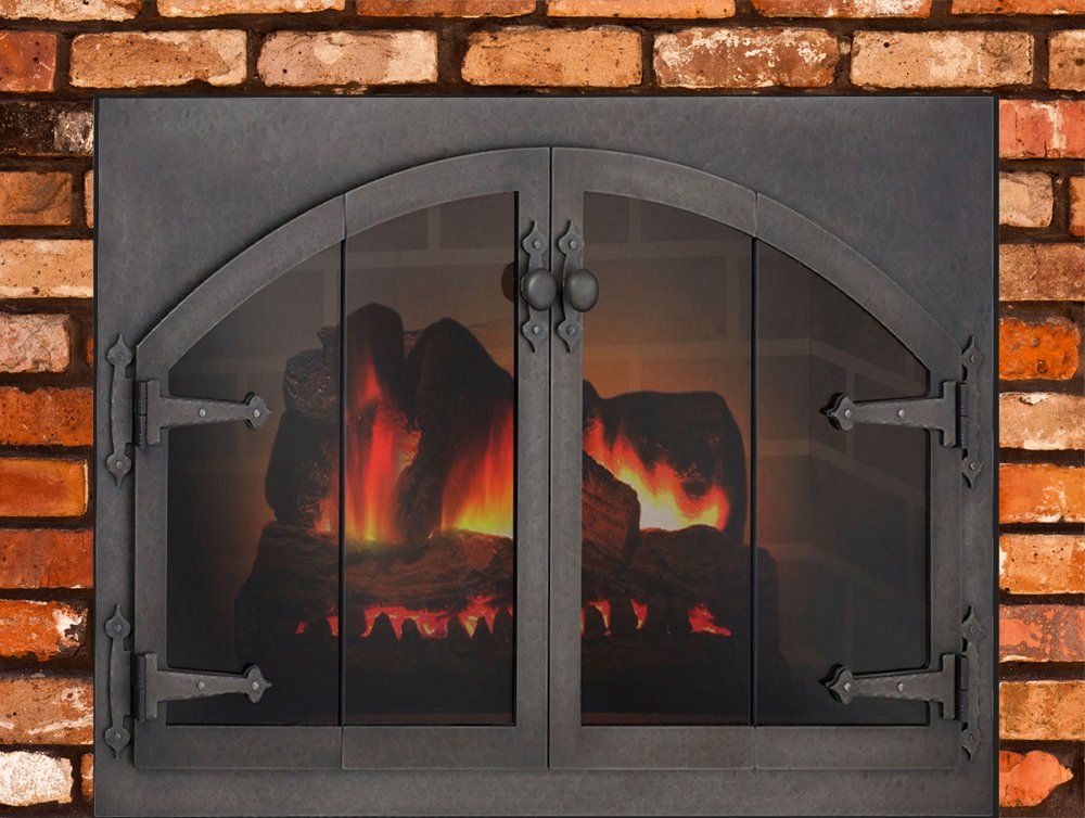 Fireplace with arched glass doors, flames burning behind them against a brick wall.