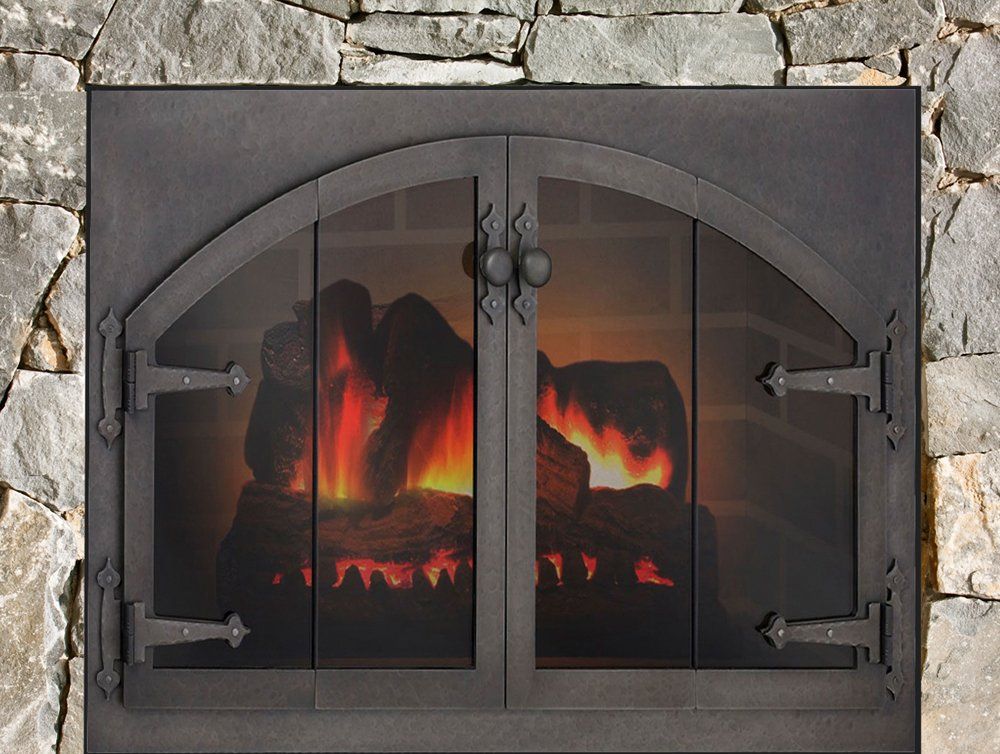 Fireplace with arched doors and decorative hardware, set in a stone wall, fire burning inside.
