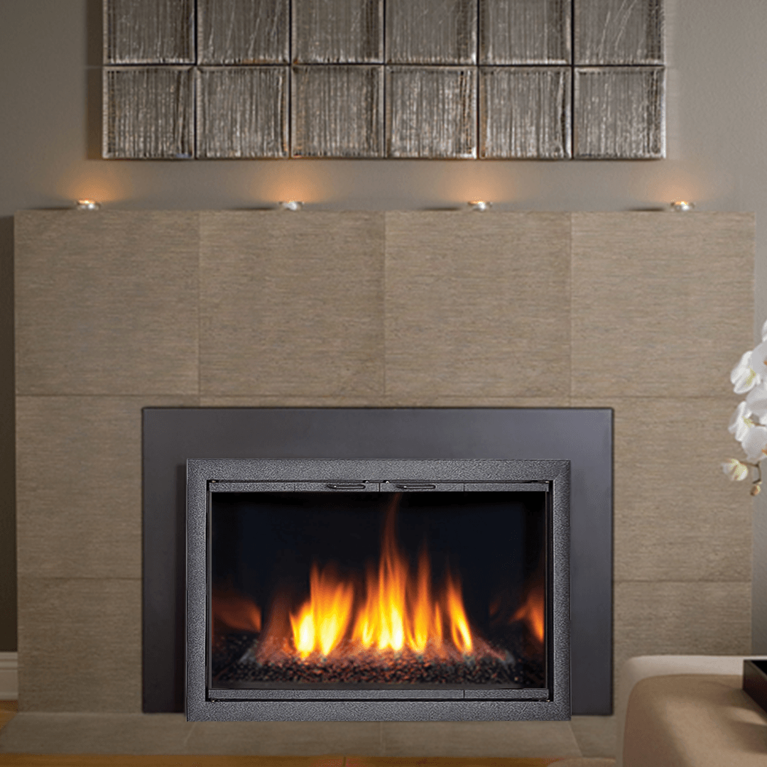 Fireplace with a burning flame, gray frame, and beige tiled surround; decorative wall art above.