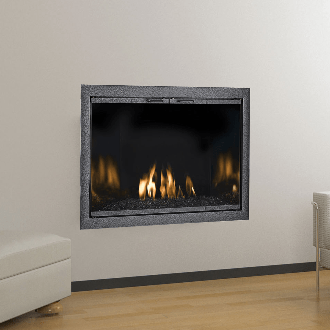 A modern fireplace recessed in a white wall, flames glowing. Gray stone frame, wooden floor.