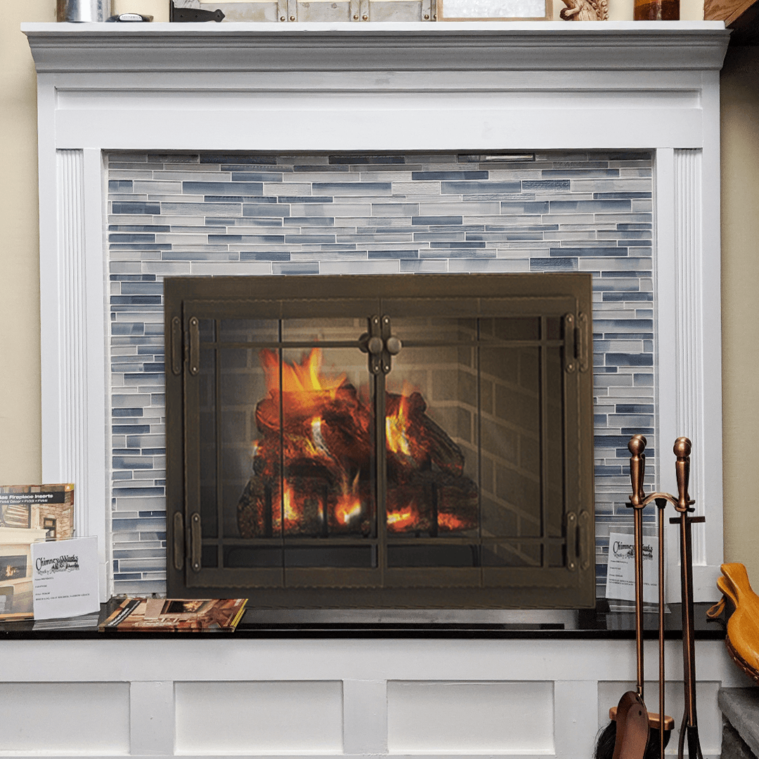 Fireplace with blue tiled backsplash, lit fire, and black mantel.
