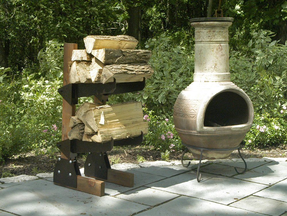 Outdoor scene: a chiminea and a firewood rack stacked with logs on a patio.