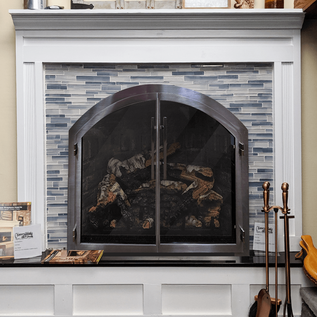 Fireplace with blue tile surround, stainless steel screen, white mantel, and black hearth.