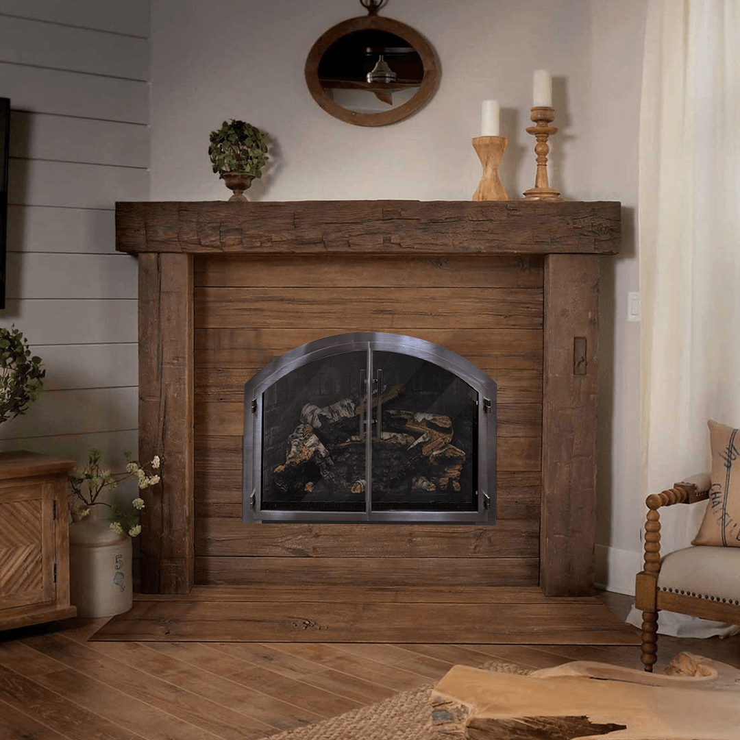 Rustic fireplace with wood mantel, screen, and logs, in a cozy living room.
