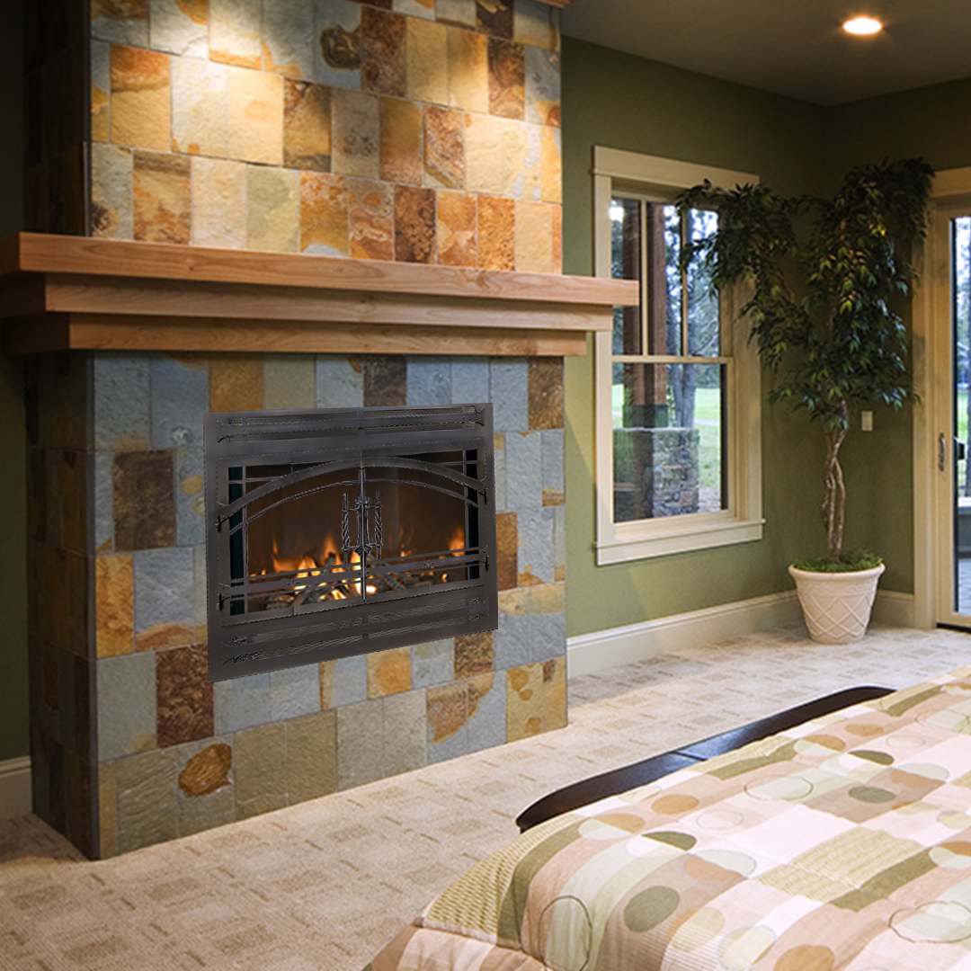 Fireplace with stone tile surround, wood mantel, and a lit fire in a green-walled room.