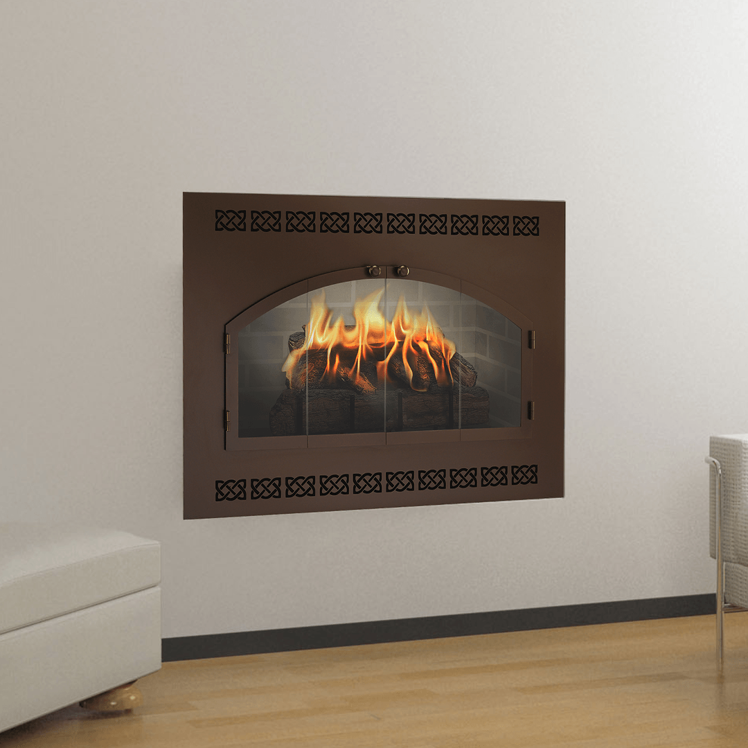 A brown, inset fireplace with a glowing fire against a white wall and wooden floor.
