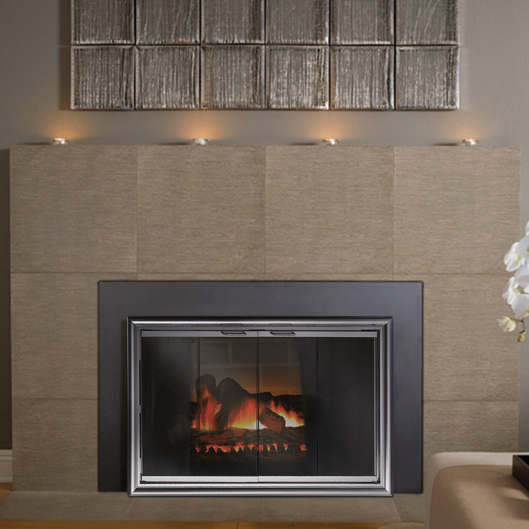 Fireplace with lit fire behind glass, tan tile surround, and candles on the mantle.