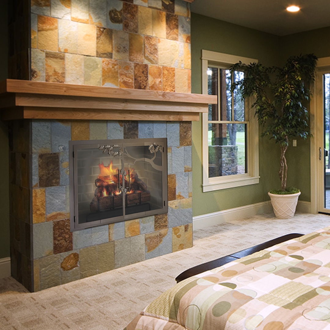 Fireplace with stone surround, wooden mantel, and glass doors. A bed and plant are nearby.