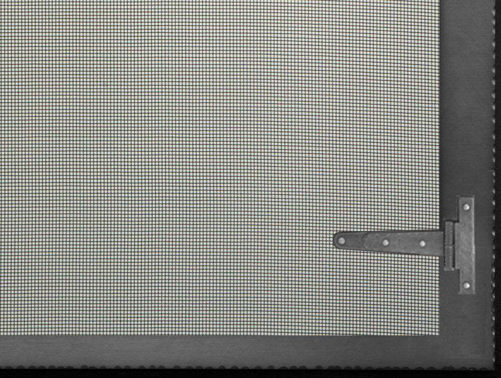 Black screen with a hinge in the corner. Mesh screen with a dark frame and square grid pattern.