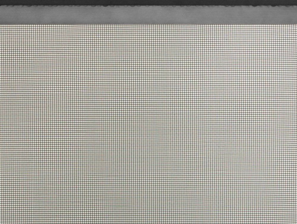 Close-up of a white surface with a fine, dark grid pattern and a gray border at the top.