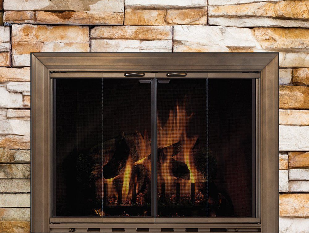 Fireplace with flames behind a mesh screen and within a stone surround.