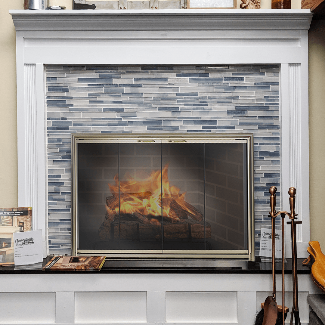 Fireplace with blue tiled surround, flames behind a screen, and white mantel.