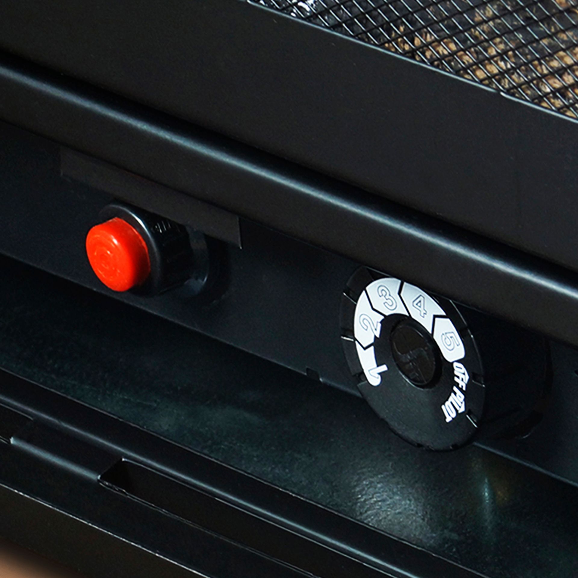 Black heater controls with a red button and a circular dial with white markings.