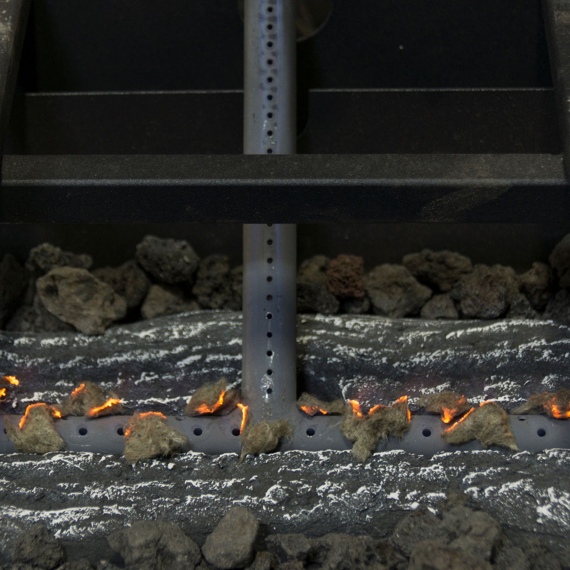 Fire pit detail with lava rocks and flames.