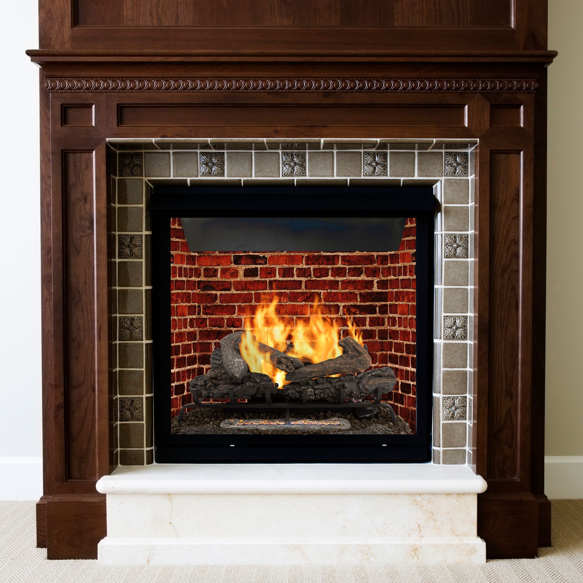 Fireplace with burning fire, wood mantel, brick interior, and tiled border.