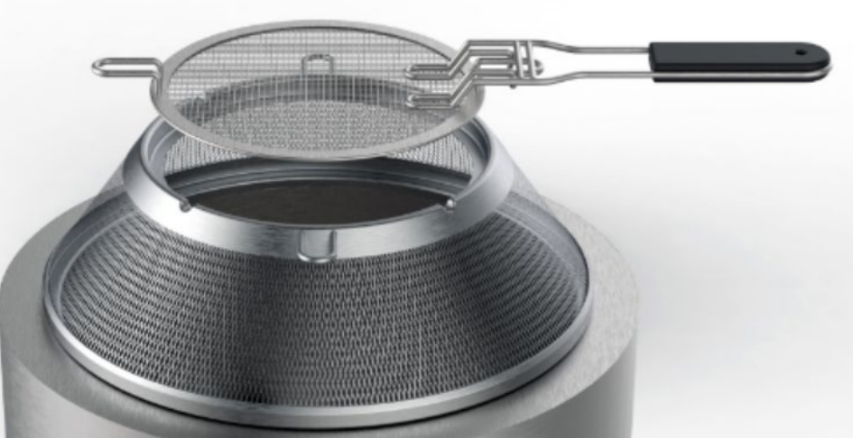 Metal strainer with black handle, resting inside a mesh-lined cooking pot.
