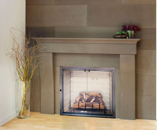 Fireplace with tan stone surround, black fire screen, logs, and a mantel with greenery.