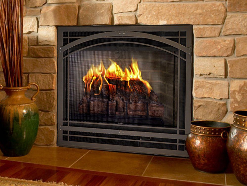 Fireplace with burning logs, stone surround, black metal screen, and decorative vases.