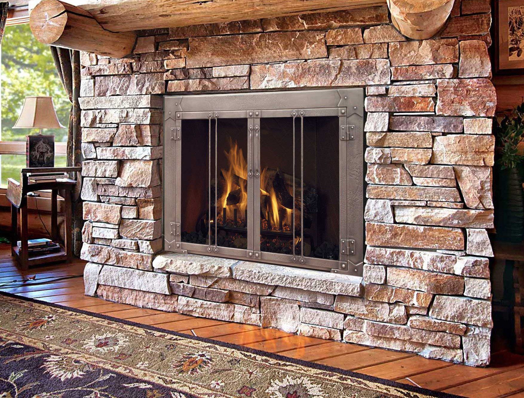 Stone fireplace with glass doors and burning flames.