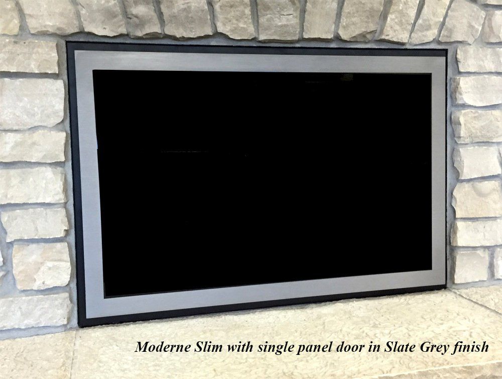 Modern Slim fireplace door, Slate Grey finish, within a stone wall.