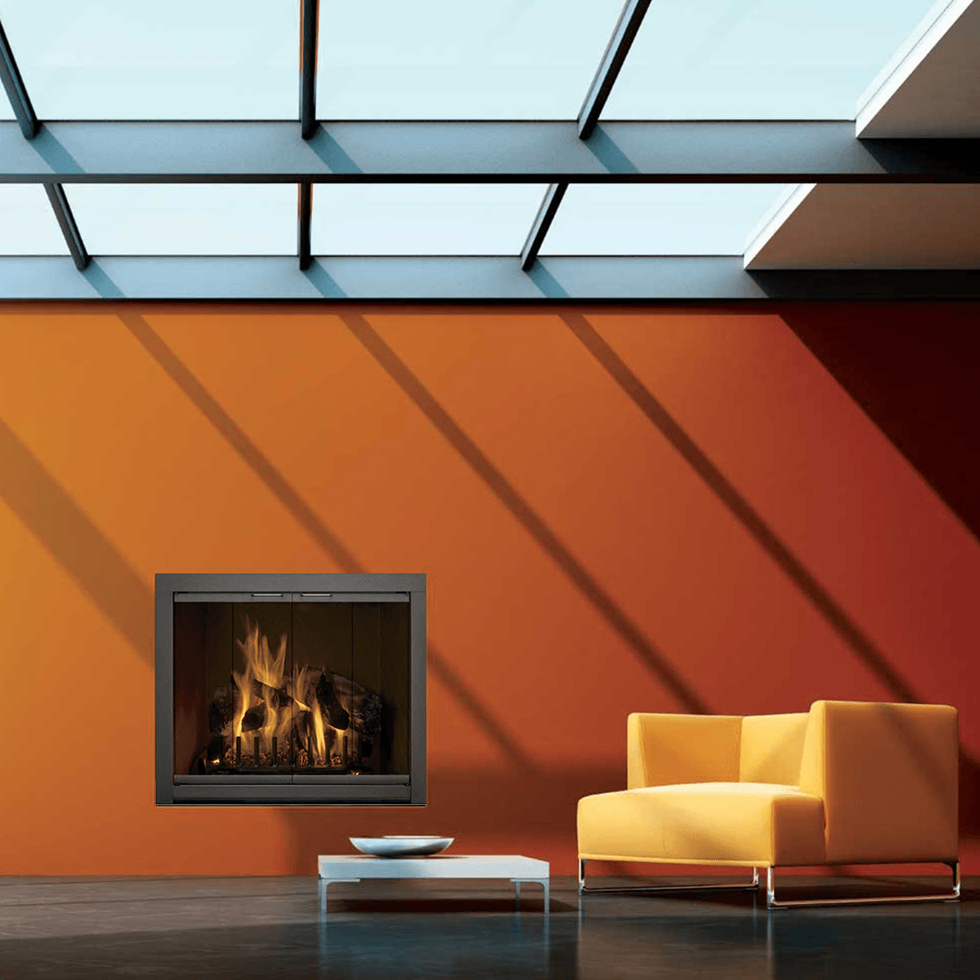 Fireplace in a room with orange wall, yellow chair, and a white coffee table under a skylight.