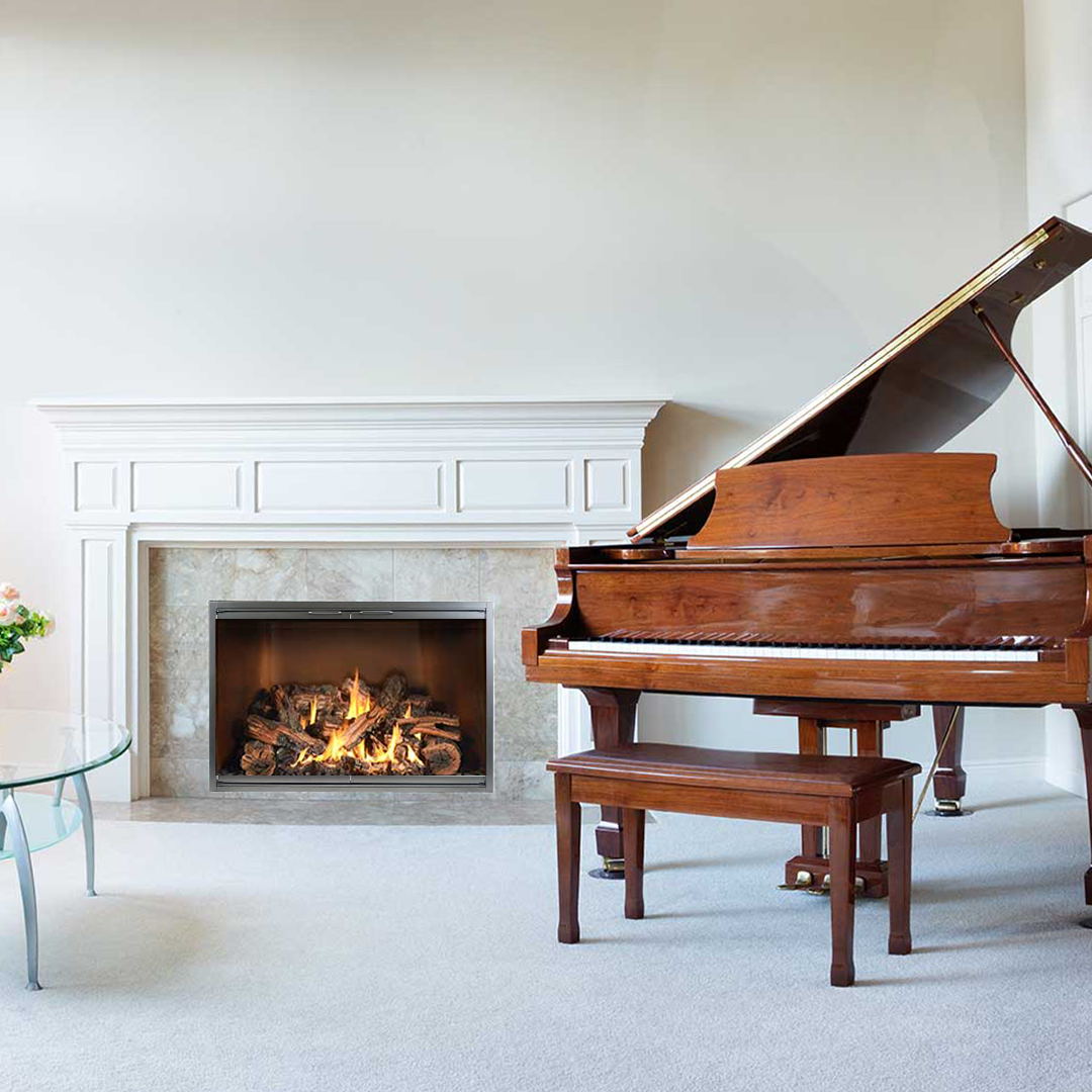 Grand piano next to a fireplace with burning logs in a white-walled room.