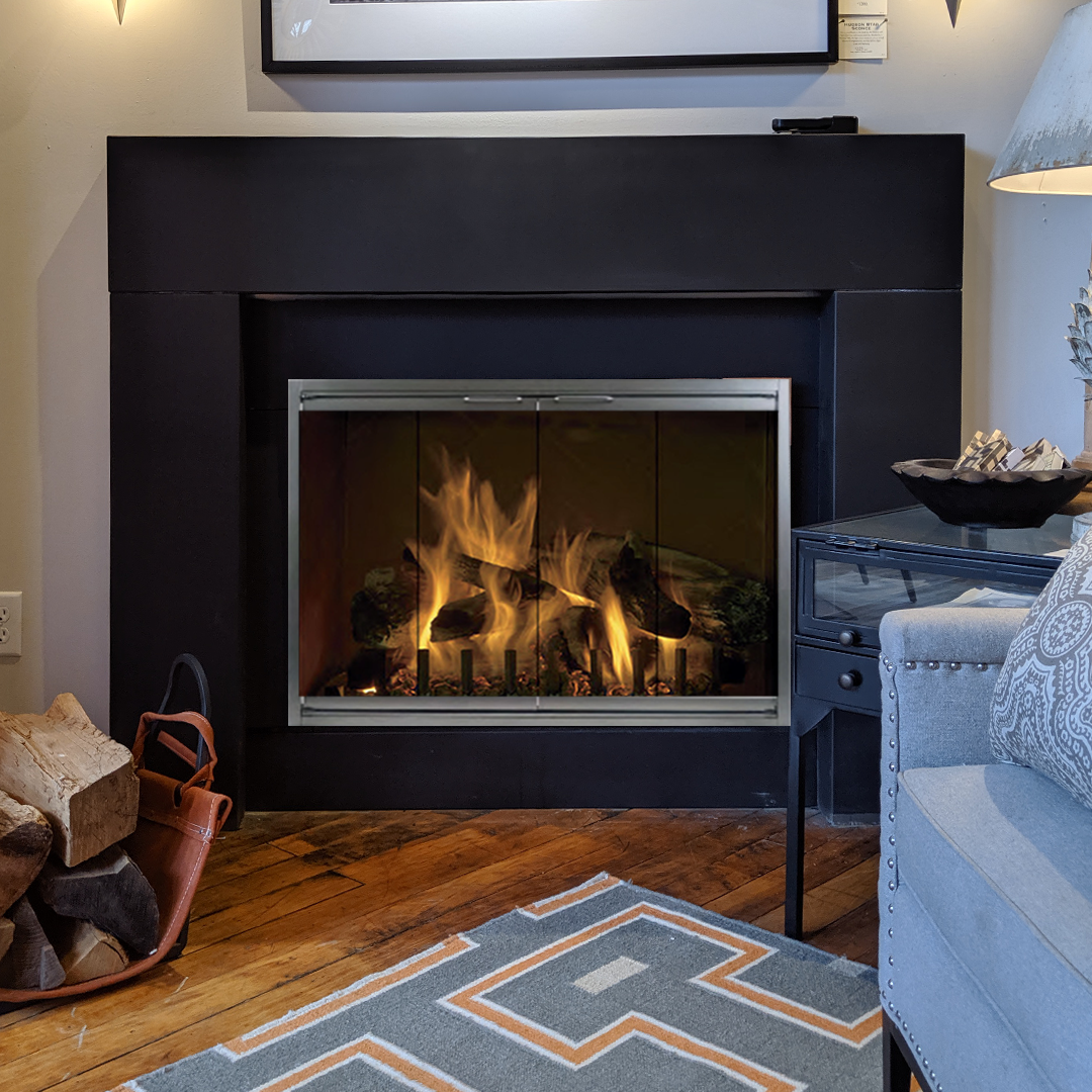 Fireplace with roaring flames inside a black surround, next to a basket of firewood and a patterned rug.