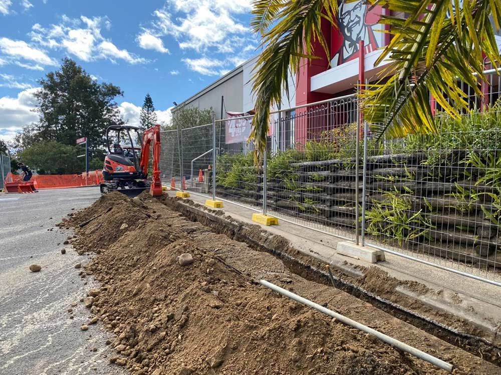 A Construction Site With a Large Pile of Dirt in Front of a Building — Mick Sawtell Electrical Pty Ltd in Lismore, NSW