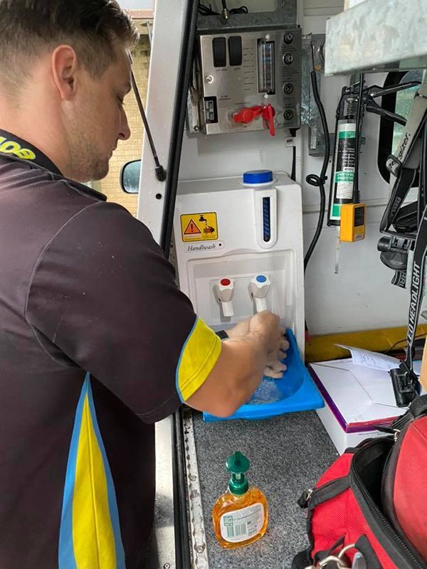 A Man is Cleaning a Water Dispenser in a Van — Mick Sawtell Electrical Pty Ltd in Casino, NSW