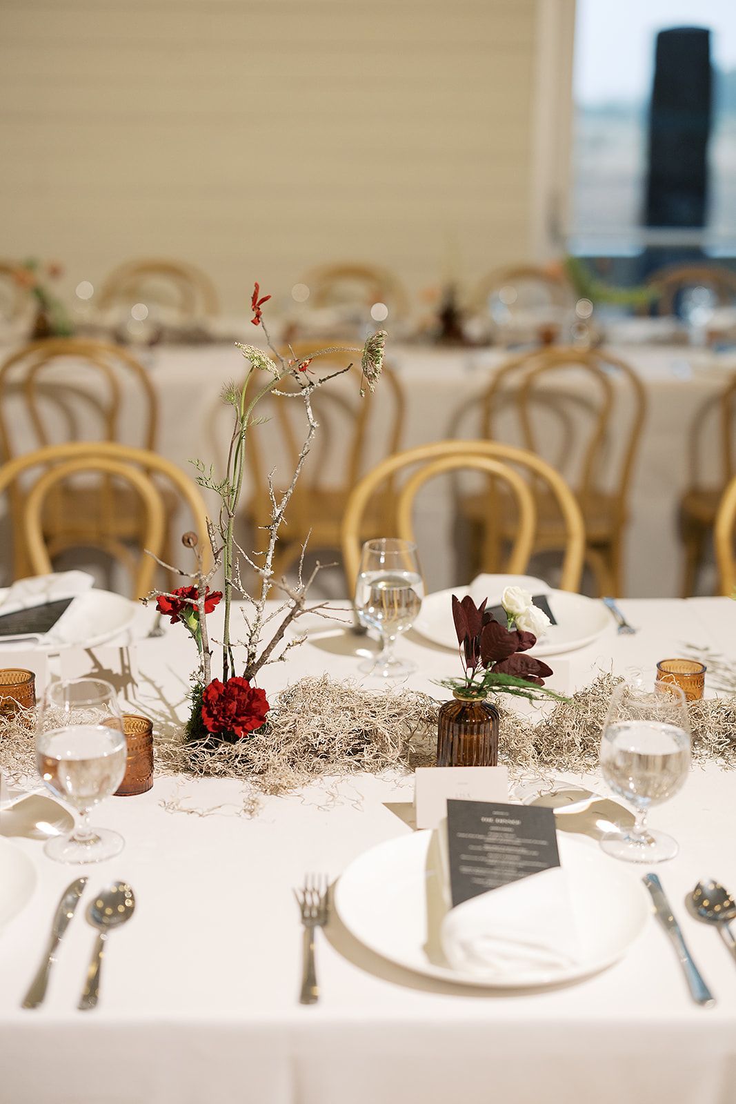 Elegant banquet table with white linens, gold chairs, and floral centerpieces in a softly lit dining room