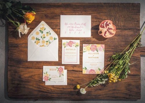 Floral wedding stationery suite with envelopes and dried flowers on a wooden table