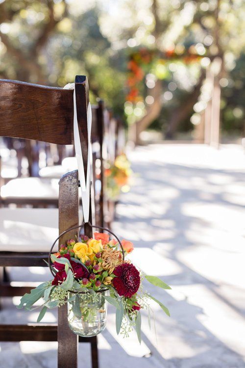 Flower arrangement tied to a wooden chair outdoors in soft sunlight