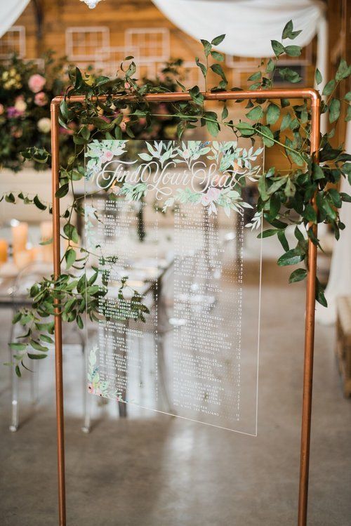 Clear acrylic wedding sign framed with copper, decorated with greenery