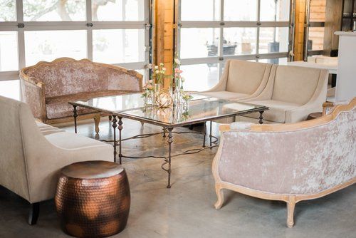 Elegant lounge with beige and brown sofas вокруг a glass coffee table near large windows