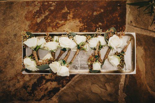 White floral letter decorations arranged on a rectangular tray over a rustic brown surface