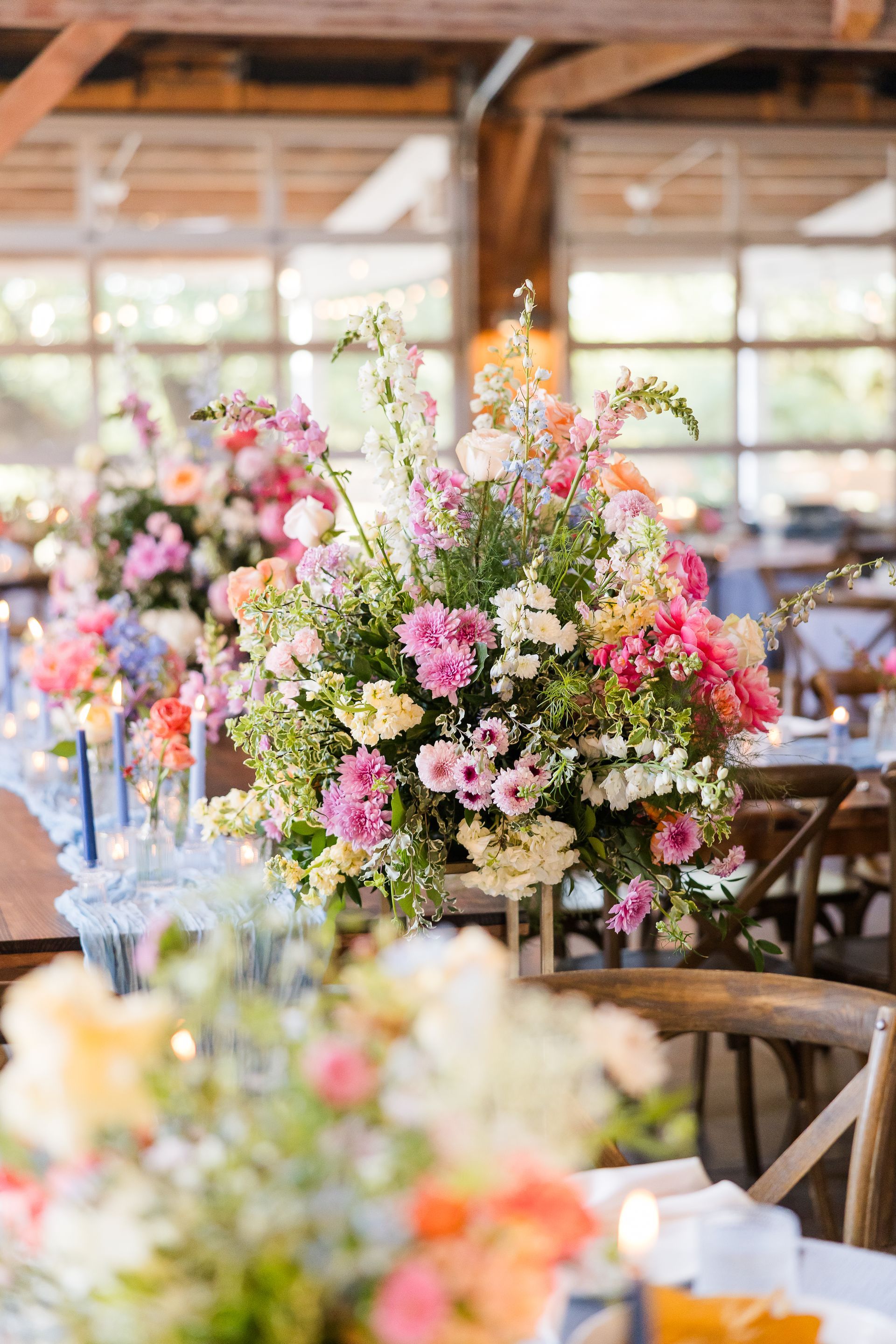 Flower arrangements on tables in a bright rustic event hall